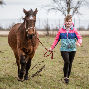 Mädchen läuft mit ihrem Pferd auf dem Pferdehof in Burkersroda